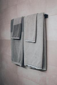 eine Gruppe Handtücher, die an einer Wand im Bad hängen in der Unterkunft Central Apartment - culture & nightlife in one in Visp