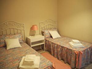 een slaapkamer met 2 bedden en een tafel met een lamp bij Cal Xambu in Cambrils