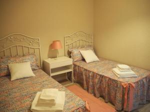 a bedroom with two beds and a table with a lamp at Cal Xambu in Cambrils