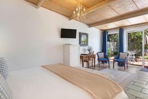a bedroom with a bed and a dining room at Morningside Cottage in Tokai