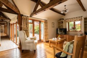un soggiorno con pavimenti in legno e travi in legno. di Garden Cottage at Eaton Manor a Eaton