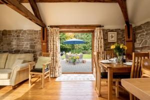 a dining room with a table and chairs and an open door at Garden Cottage at Eaton Manor in Eaton