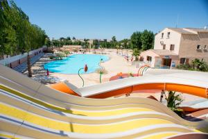 a slide at a resort with a swimming pool at MobileHome 8 Personnes avec Clim situé aux Sables du Midi in Valras-Plage