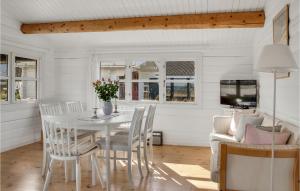 a dining room with a white table and chairs at Cozy Home In Rdby With Kitchen in Rødby