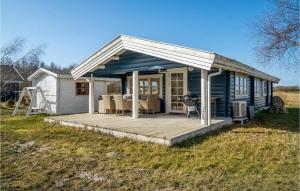 a small blue house with a wooden deck at Cozy Home In Rdby With Kitchen in Rødby