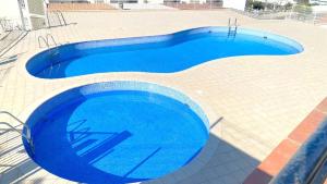 uma grande piscina azul num piso de azulejo em Acapulco b5 em Roses