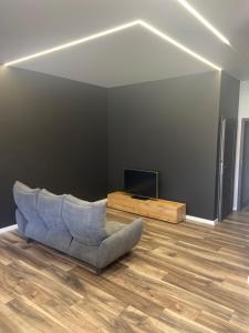 a living room with a couch and a television at Apartamentai in Raseiniai