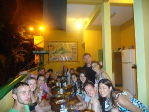 a group of people posing for a picture at a party at Harmoni Hostel & Pousada in Abraão