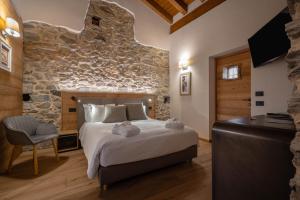 a bedroom with a large bed and a stone wall at Les Plaisirs d'Antan in Aosta