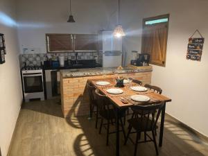 a kitchen with a wooden table with chairs and a counter at Chalés Samambaia in Bananeiras