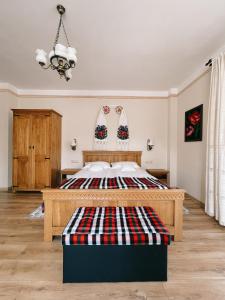 a bedroom with a bed with a plaid blanket on it at Glodeanca in Glod