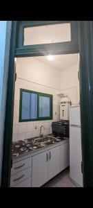 y cocina con fregadero, fogones y nevera. en San Telmo Apartment en Buenos Aires