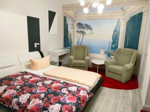 - une chambre avec un lit et deux chaises dans l'établissement Hotel Haegert, à Neustrelitz