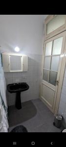baño pequeño con lavabo y puerta en San Telmo Apartment en Buenos Aires