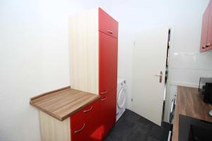 baño con armario rojo y lavadora en Apartment with terrace in Wuppertal, en Wuppertal
