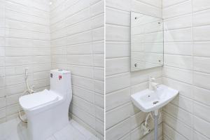 a white bathroom with a toilet and a sink at FabHotel Swess in Agra