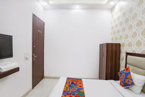 a bedroom with a bed and a television in it at FabHotel Swess in Agra