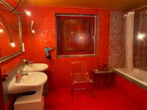 a red bathroom with two sinks and a bath tub at Extravagantes ganzes Haus am Staffelsee (DHH), Villa Kunterbunt in Seehausen am Staffelsee