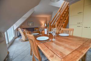 a dining room with a wooden table and chairs at Strandoase Typ STO-A STRANDOASE Whg. SO8 in Wustrow