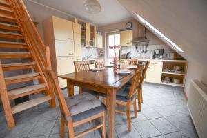 a kitchen with a wooden table and chairs and a staircase at Strandoase Typ STO-A STRANDOASE Whg. SO8 in Wustrow
