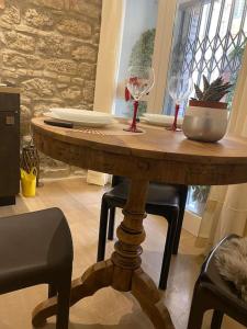 uma mesa de madeira com cadeiras e copos de vinho em Duca apartment em Perugia