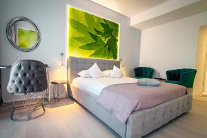 1 dormitorio con cama, espejo y silla en Continental Forum Arad en Arad
