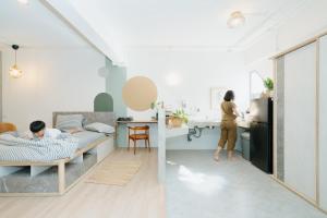 a room with two beds and a woman in a kitchen at Dokdin's Family in Patong Beach