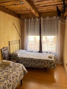 a bedroom with two beds and a window at Albergue hostal Sahagún in Sahagún