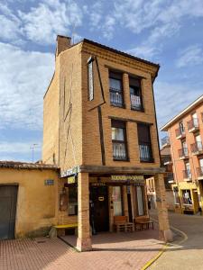 un antiguo edificio de ladrillo en una calle de la ciudad en Albergue hostal Sahagún, en Sahagún