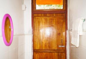una puerta de madera en un baño con espejo en Yumasham Homestay, en Darjeeling