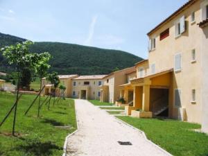 a row of buildings with a mountain in the background at Le Hameau des Sources by Ateya in Montbrun-les-Bains
