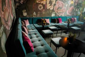 ein Zimmer mit einer Couch und einigen Tischen und Stühlen in der Unterkunft JAMS Music Hotel Munich in München