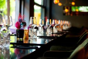 uma longa mesa com copos de vinho e flores em JAMS Music Hotel Munich em Munique