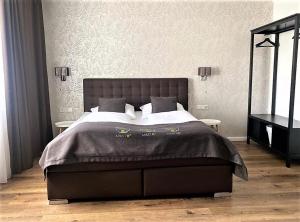 a bedroom with a large bed with a black headboard at City Hotel ApartM3 am Park in Bad Oeynhausen