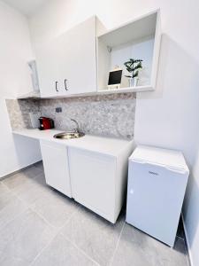 a kitchen with white cabinets and a sink at sky inn with wonderful Acropolis view in Neos kosmos in Athens +38 photos