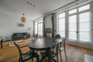 sala de estar con mesa, sillas y sofá en Appartement de Prestige - Grand Varenne, en París