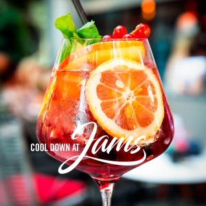 ein Getränk mit Orangen und Kirschen im Glas in der Unterkunft JAMS Music Hotel Munich in München