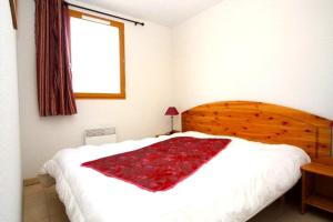 a bedroom with a bed with a red blanket on it at Le Hameau des Sources by Ateya in Montbrun-les-Bains