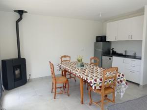 una sala da pranzo con tavolo e sedie e una cucina di Maison neuve - Mesquer - Plage, Rando, Vélo a Mesquer 1 altra foto