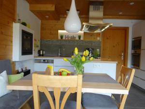 una cocina con una mesa con un jarrón de flores. en MEB Appartement en Blaichach