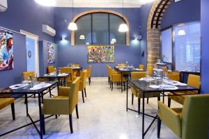 a dining room with tables and yellow chairs at Quintocanto Hotel & Spa in Palermo