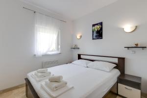 - une chambre avec un lit blanc et des serviettes dans l'établissement Villa Rondine Apartments - Happy Rentals, à Novigrad