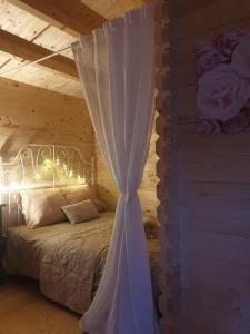 a bedroom with a bed with a white canopy at Le Cottage OneHeart in Saverne