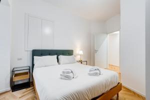 1 dormitorio con 1 cama blanca grande y 2 toallas en Apt in the heart of the city, en Roma