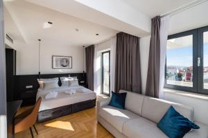 a hotel room with a bed and a couch at Miramare Hotel in Zadar