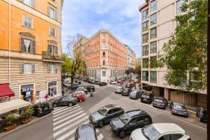 una calle de la ciudad con coches y edificios aparcados en Apt in the heart of the city, en Roma