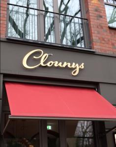 a store sign with a red awning on a building at Clounys Hotel in Hamburg