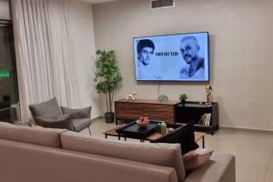 sala de estar con sofá y TV de pantalla plana en מהממת ומרווחת בגבעת שמואל, en Giv‘at Shemuʼel