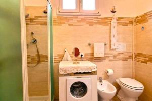 La salle de bains est pourvue de toilettes, d'un lavabo et d'un lave-linge. dans l'établissement Trekking Lovers Vacation Home with Town View, à Minori