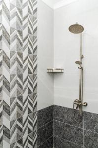a shower with a black and white tiled wall at Dosman Hotel Bishkek in Bishkek +49 photos